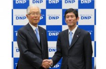 握手を交わす大日本印刷の北島義俊社長（左）と北島義斉次期社長