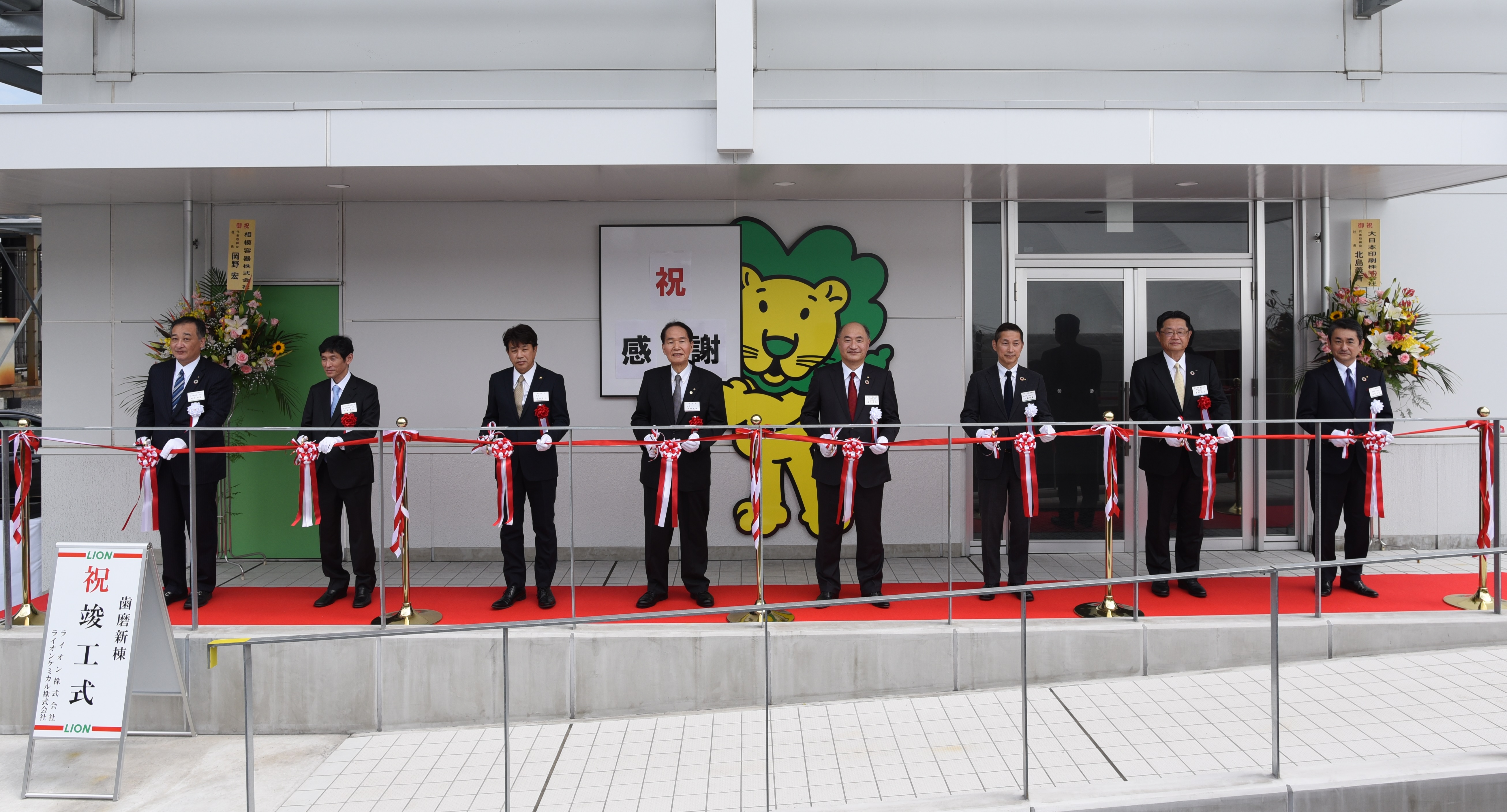 テープカットの様子(左からライオンケミカル㈱の岡野知道代表取締役社長、DNPの北島義斉代表取締役社長、香川県坂出市の有福哲二市長、香川県の浜田恵造知事、ライオン㈱の掬川正純代表取締役社長執行役員、同・久米裕康取締役上席執行役員、清水建設㈱の藤村広志取締役副社長、ライオン㈱の乘竹史智取締役執行役員)