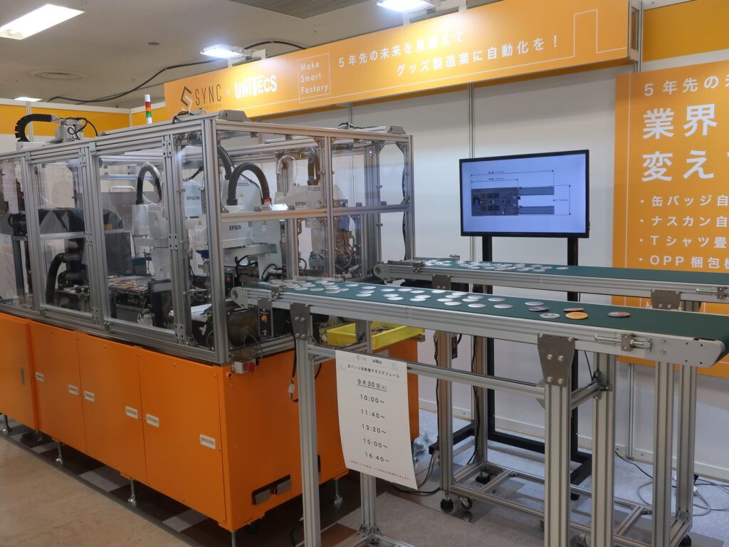シンクイノベーション　グッズ製造を自動化・自動機を開発、「缶バッジ量産型高速自動」、「簡易缶バッジ製造機」、「ナスカン取り付け自動機」、「ＯＰＰ袋入れ自動機」、「ラベル貼り自動機」、「Ｔシャツたたみ自動機」